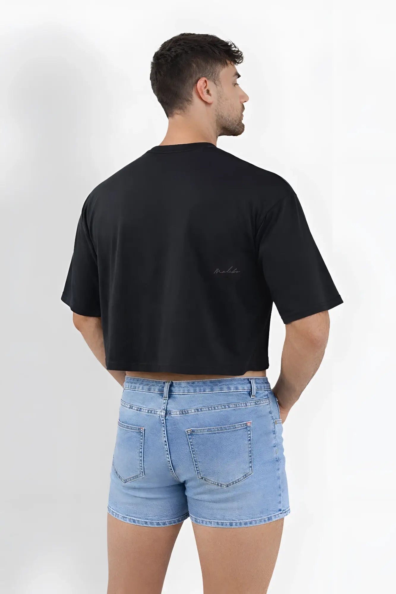 Back of oversized relaxed crop top in midnight black with short sleeves and subtle embroidered logo