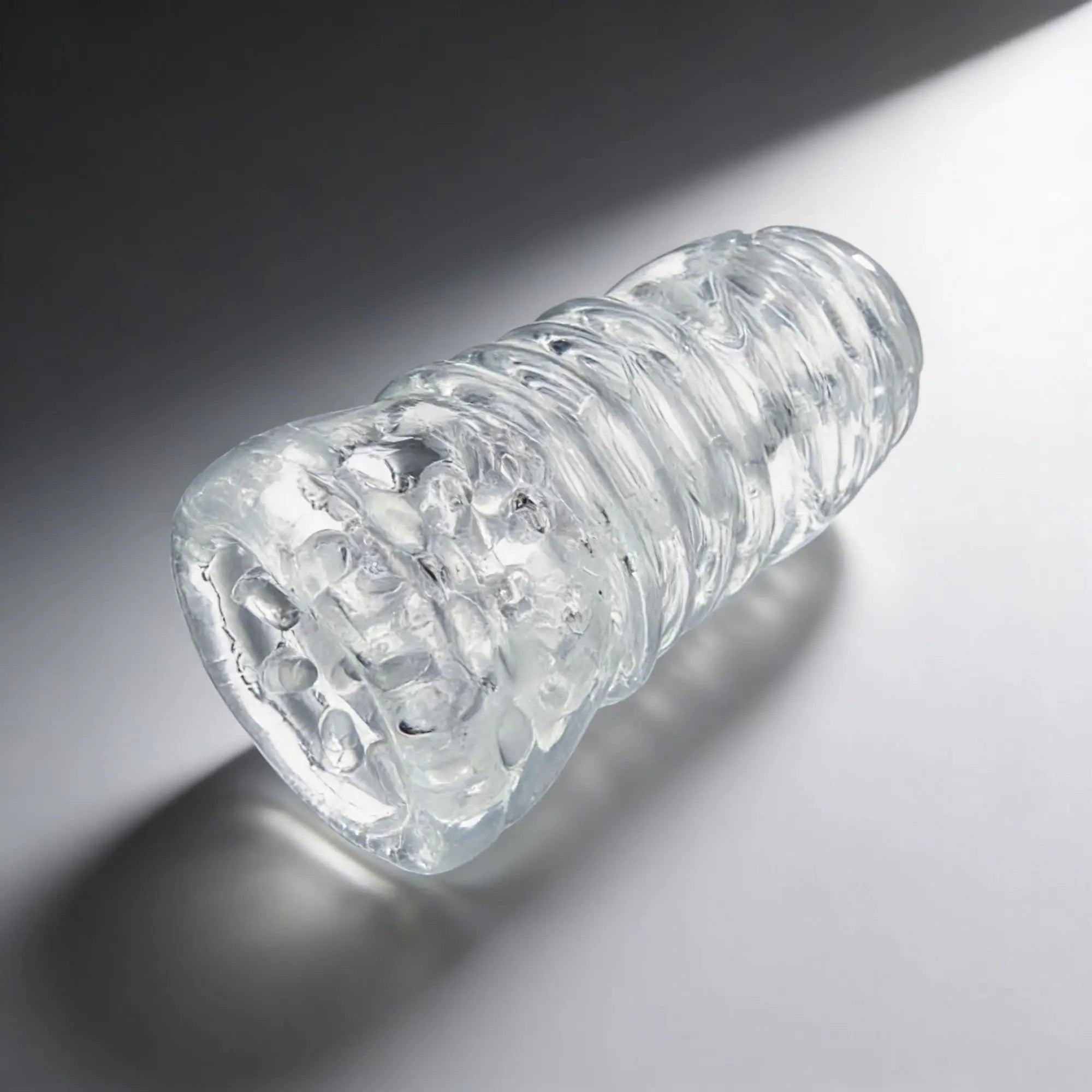 Palm-Tec LX20 Intense Stroker: A clear, cylindrical sleeve with internal textured ridges and bumps.
