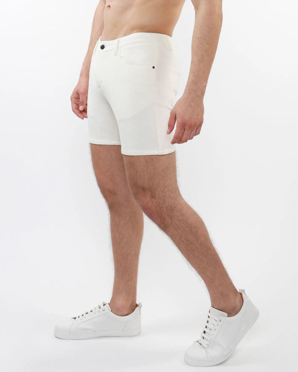 White parquet jacquard stretch knit shorts with textured fabric and black button closures in front view
