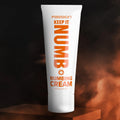 White squeeze tube of Passion Keep It Numb Numbing Cream with orange text on a dark, smoky background.