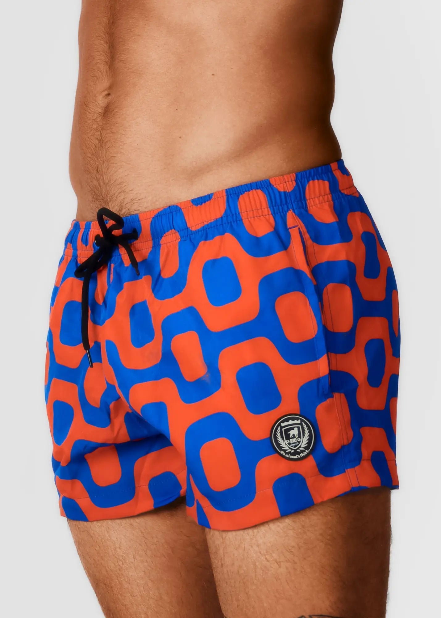 Bright orange and blue geometric-patterned Pavement swim shorts with black drawstring waistband for Italian style