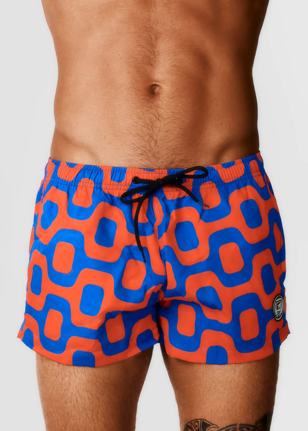 Vibrant orange and blue geometric-patterned pavement shorts with black drawstring waistband ideal for swimming