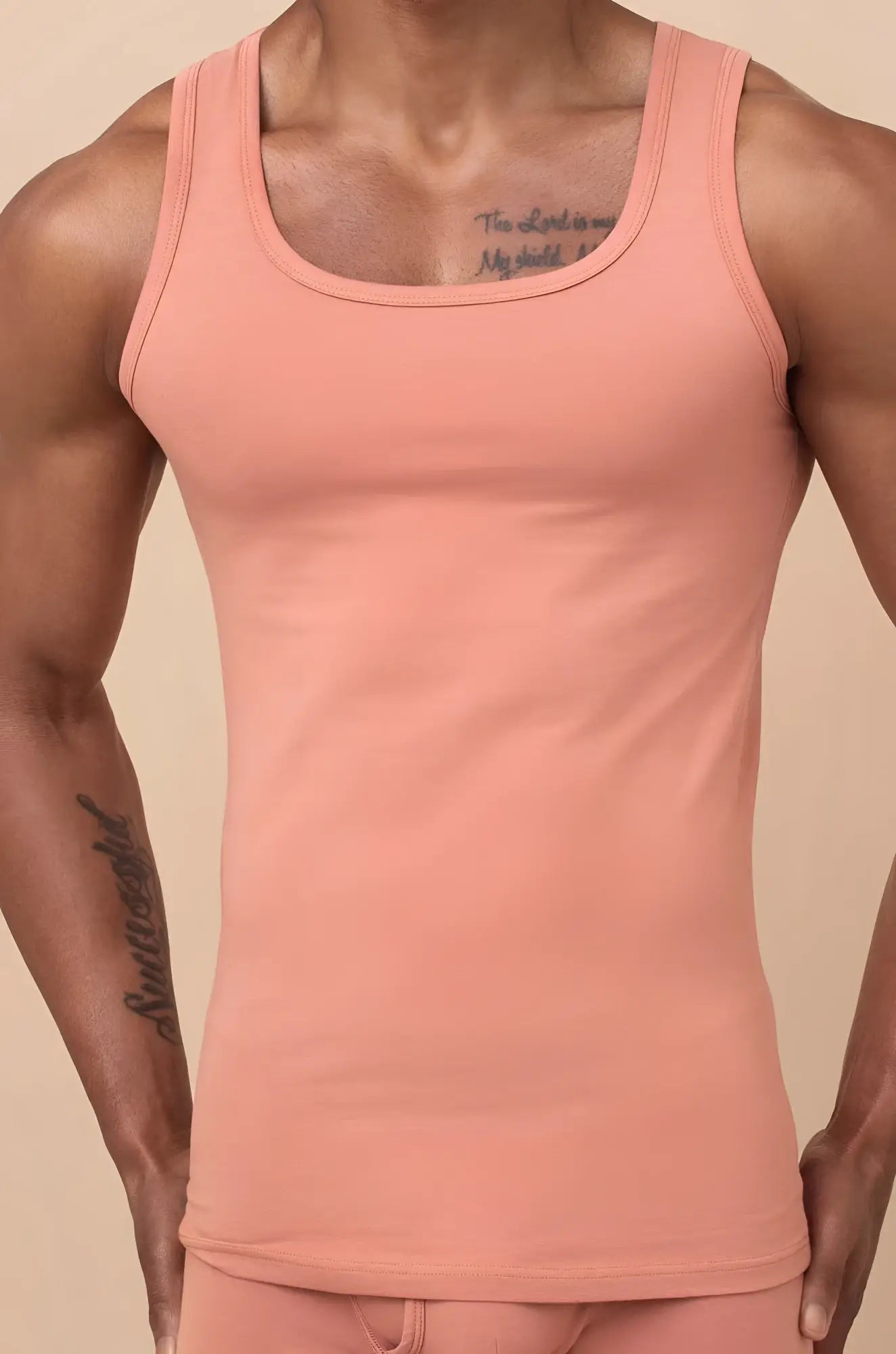 A fitted peach cream cotton tank top with a rounded neckline and thin shoulder straps