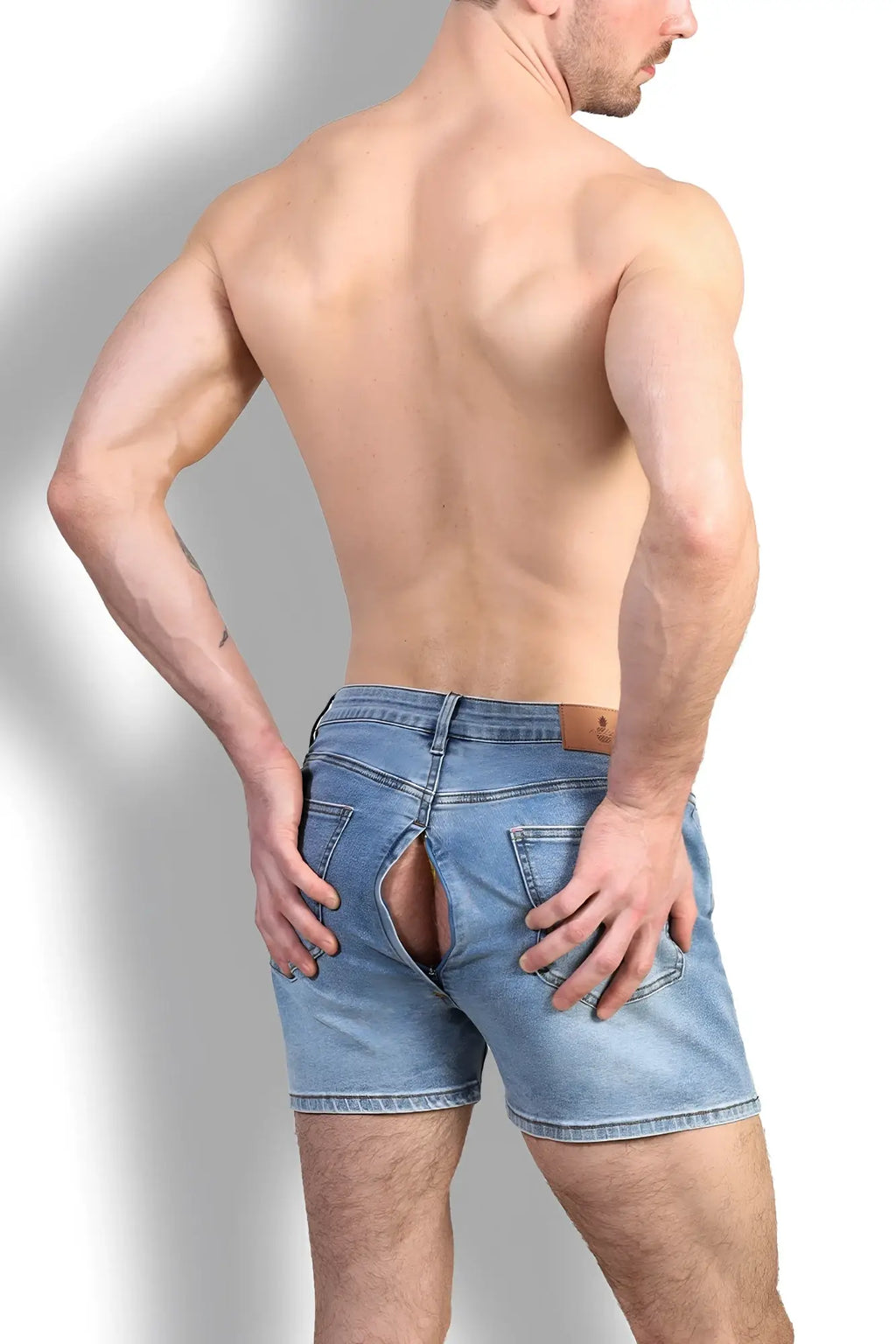 Back view of light-wash peek-a-boo denim shorts with a distinctive rear split design made of denim fabric