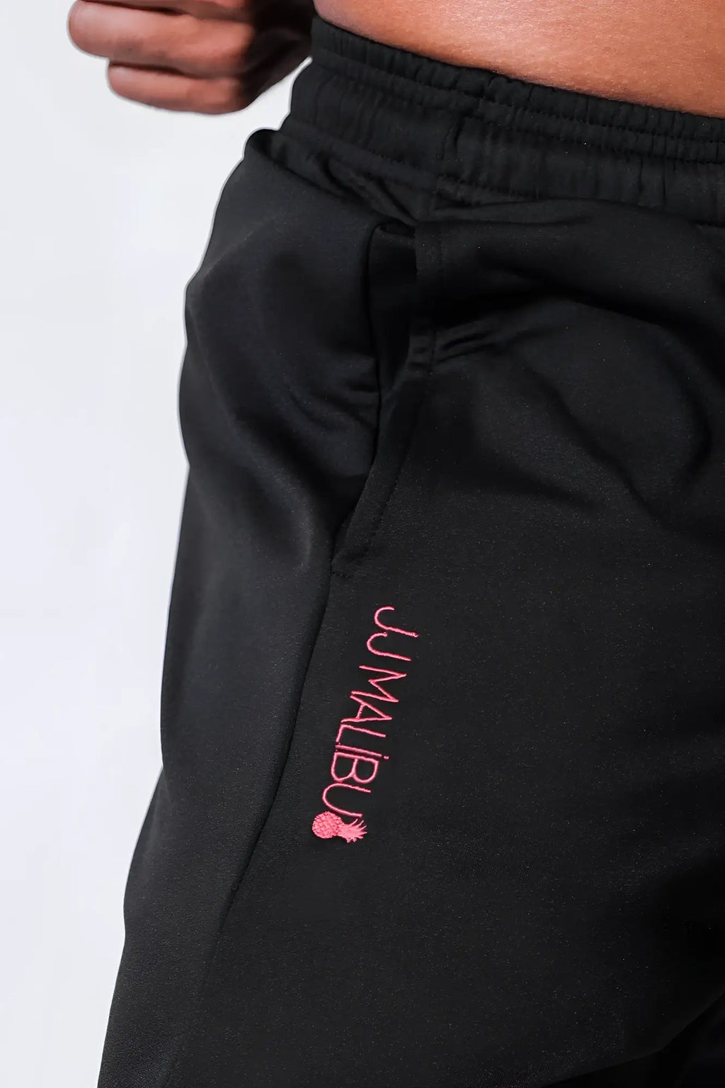 Black peek-a-boo joggers with pink jumblu branding and pineapple logo embroidered on the side seam