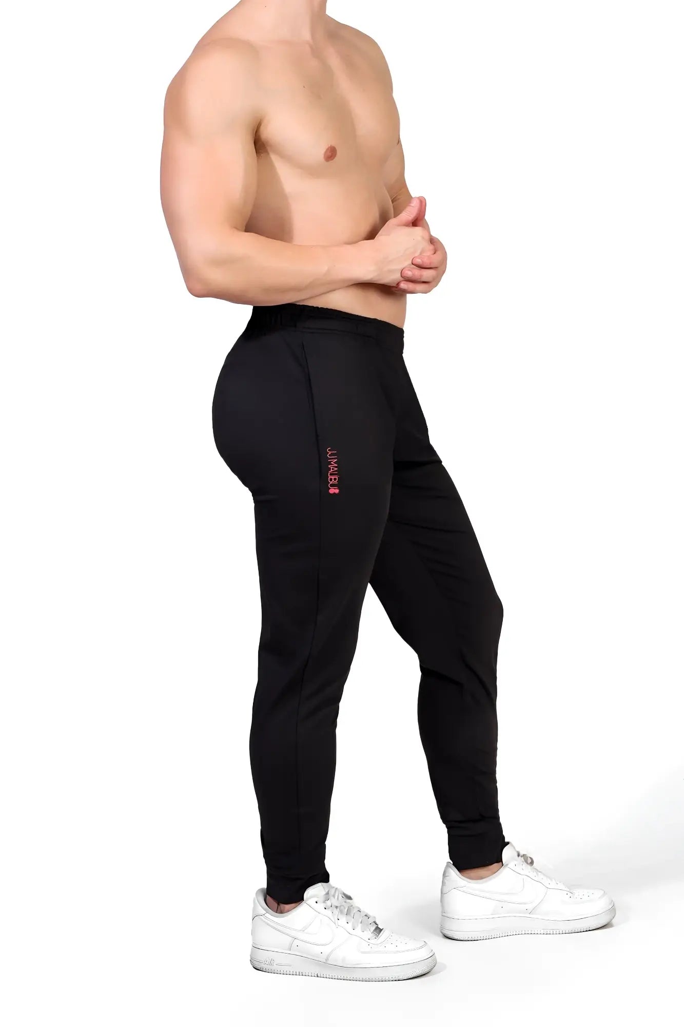 Black peek-a-boo joggers with slim fit and subtle pink branding on the side seam for athletic wear