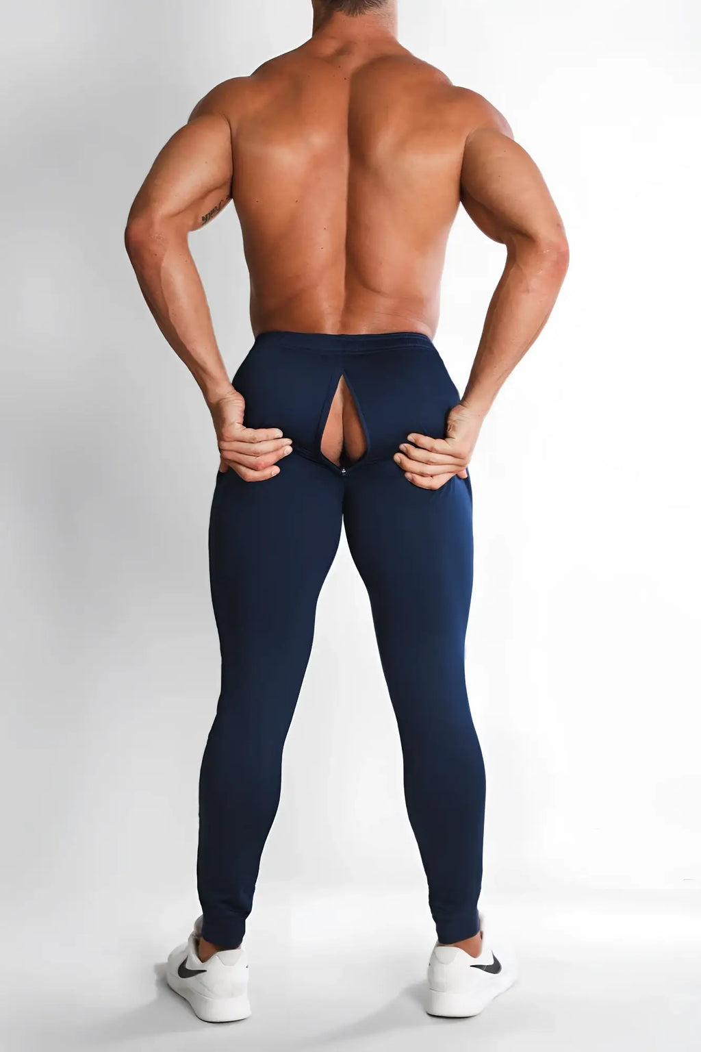 Back side of navy blue athletic leggings with distinctive rear cutout design peek-a-boo joggers navy