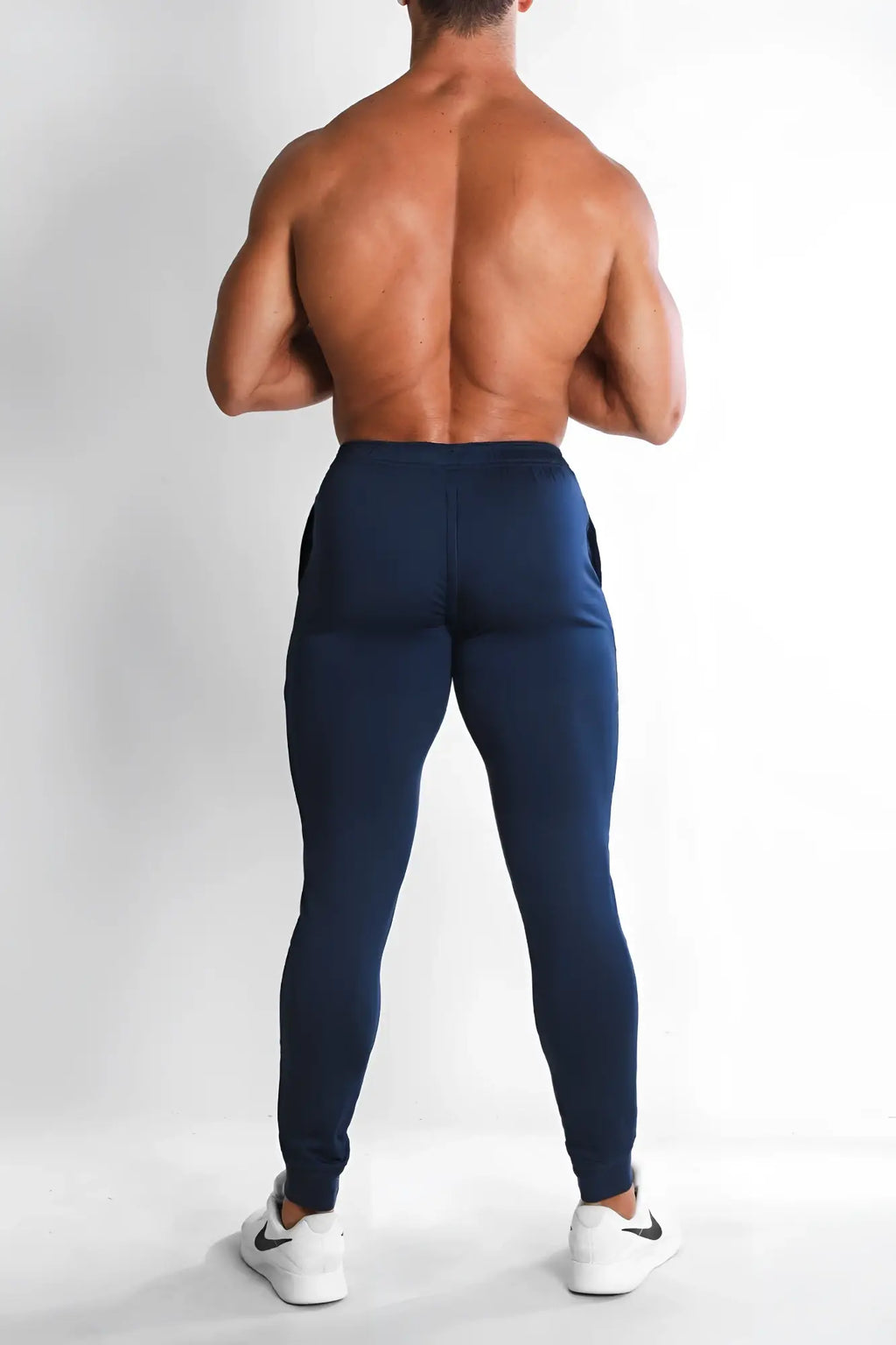 Navy peek-a-boo joggers with sleek form-fitting design and subtle side pockets ideal for athletic wear