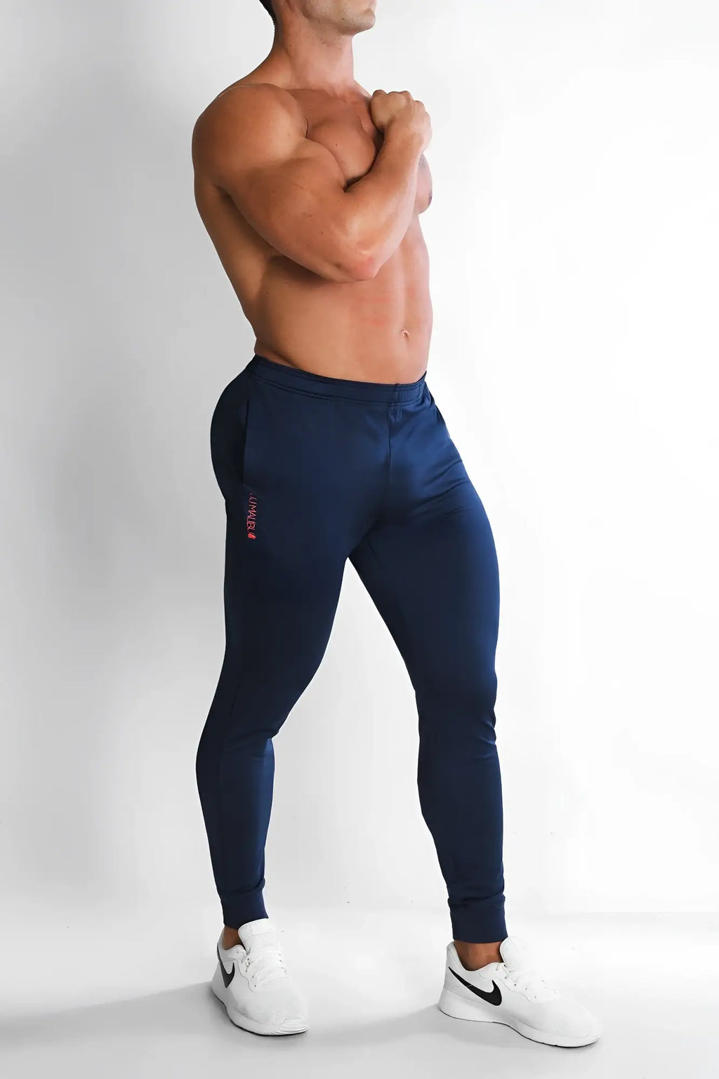 Navy peek-a-boo joggers featuring navy blue fabric with a subtle pink logo on the left thigh for athletic use