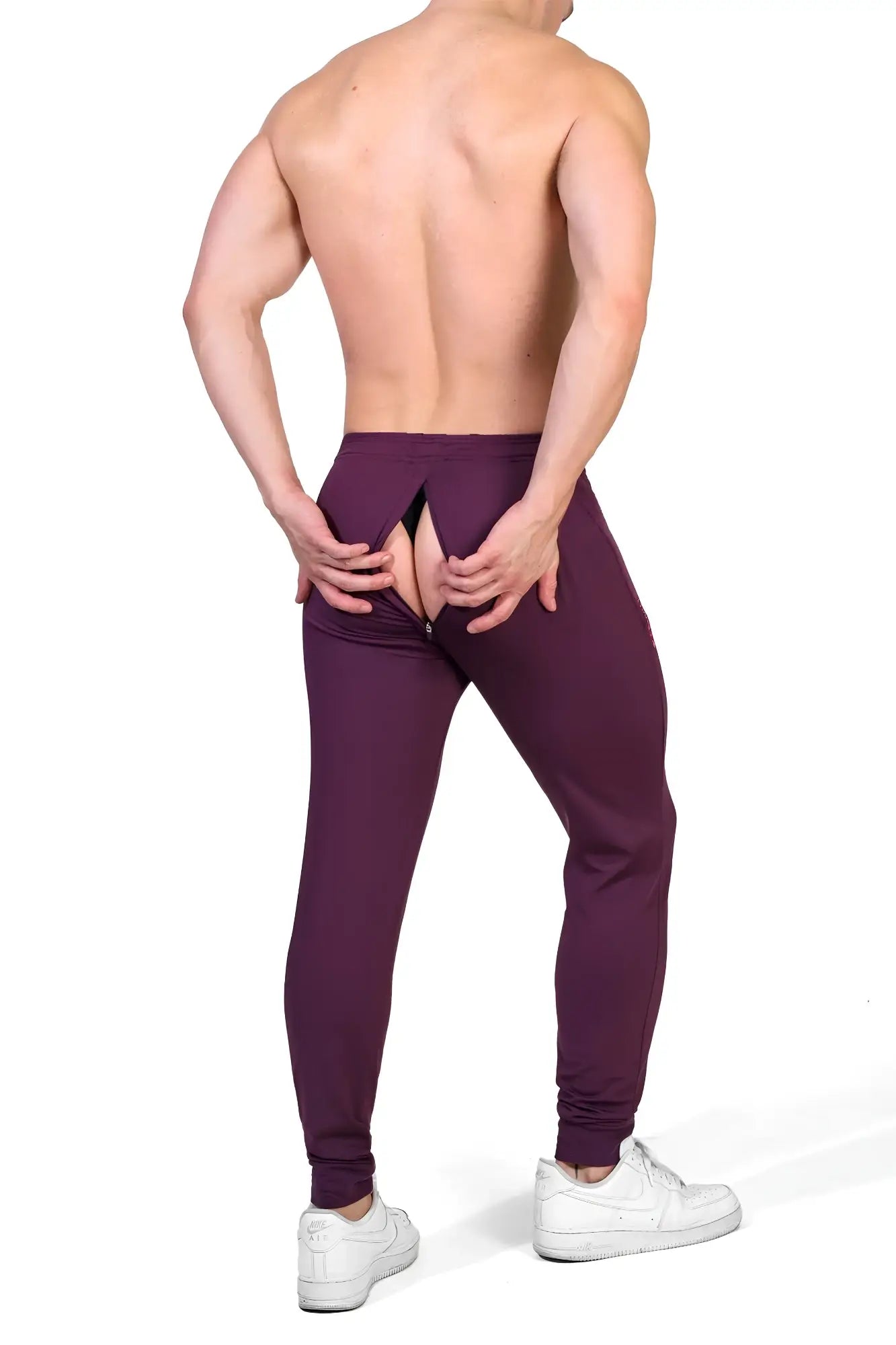 Back view of plum purple peek-a-boo joggers featuring a distinctive rear zipper opening for athletic wear