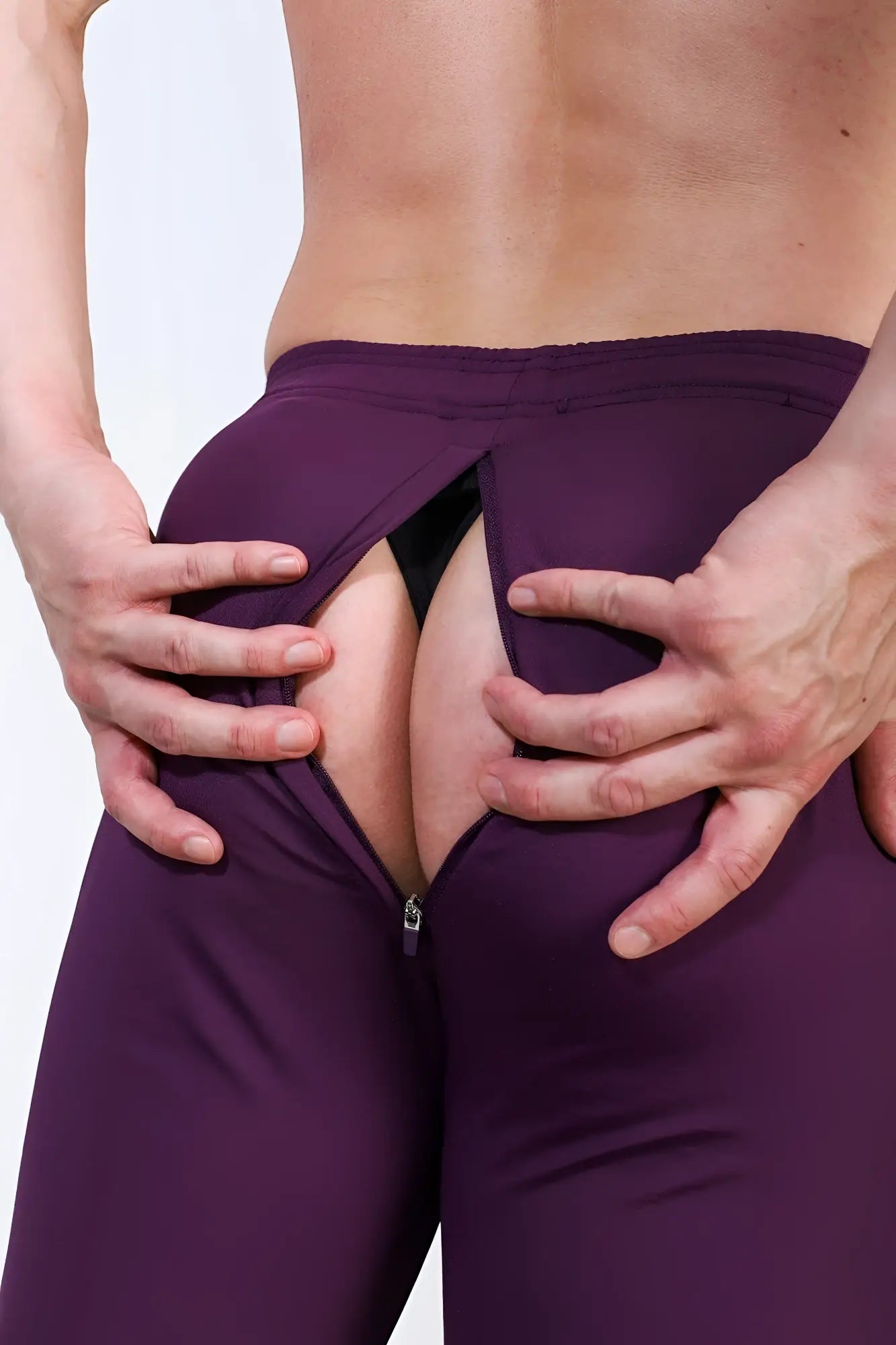 Back view of plum purple peek a boo joggers with a zipper split made of stretch fabric for athletic wear