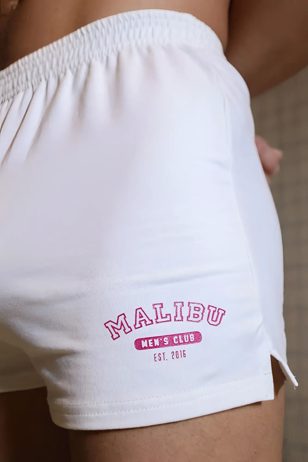 White cotton peek-a-boo varsity 2 inch short shorts with pink embroidered malibu men’s club logo marshmallow color