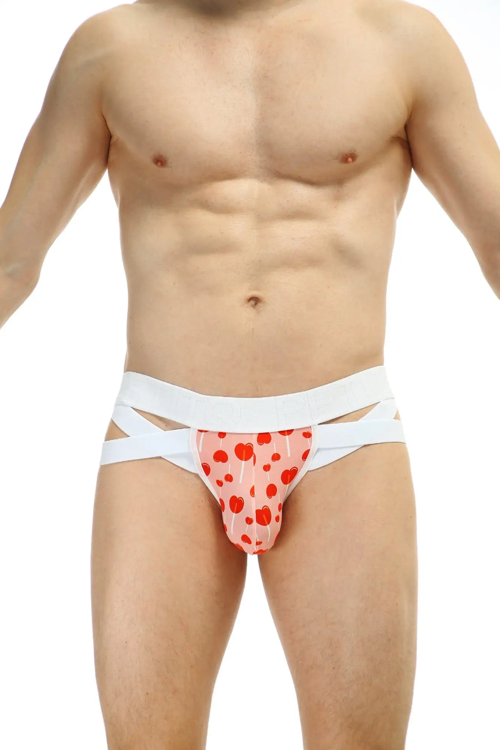Petitq jockthong bost sucette pink heart-patterned briefs with white crisscross straps front view