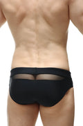 Back view of petitq swim bikini ajoupa black swim trunks featuring a sheer mesh panel and black fabric