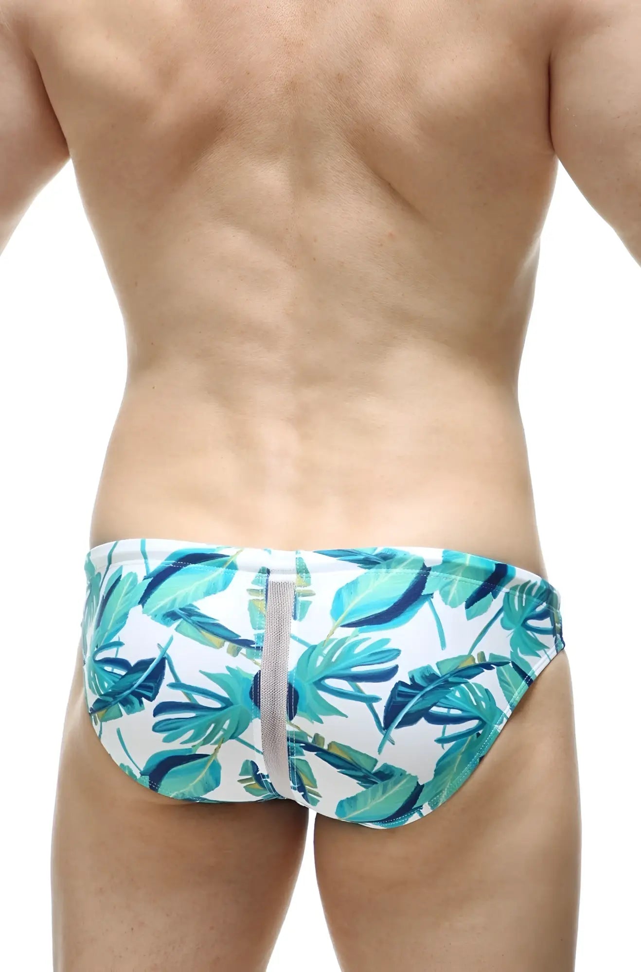 White swim trunks with vibrant teal and green tropical leaf pattern and central gray zipper petitq swim bikini tarcu macouba