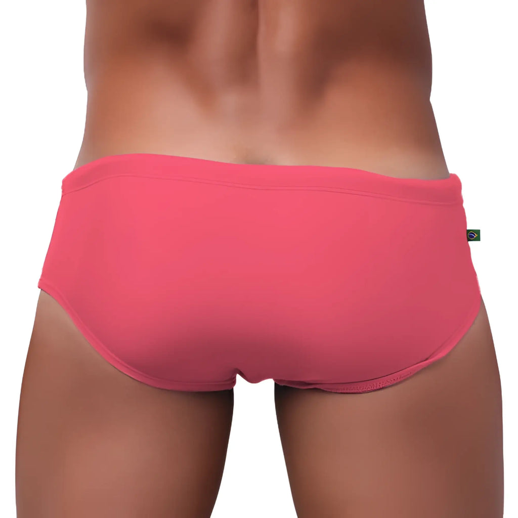 A vibrant coral pink swim trunks made of smooth form fitting fabric with a subtle elastic waistband for men’s beachwear