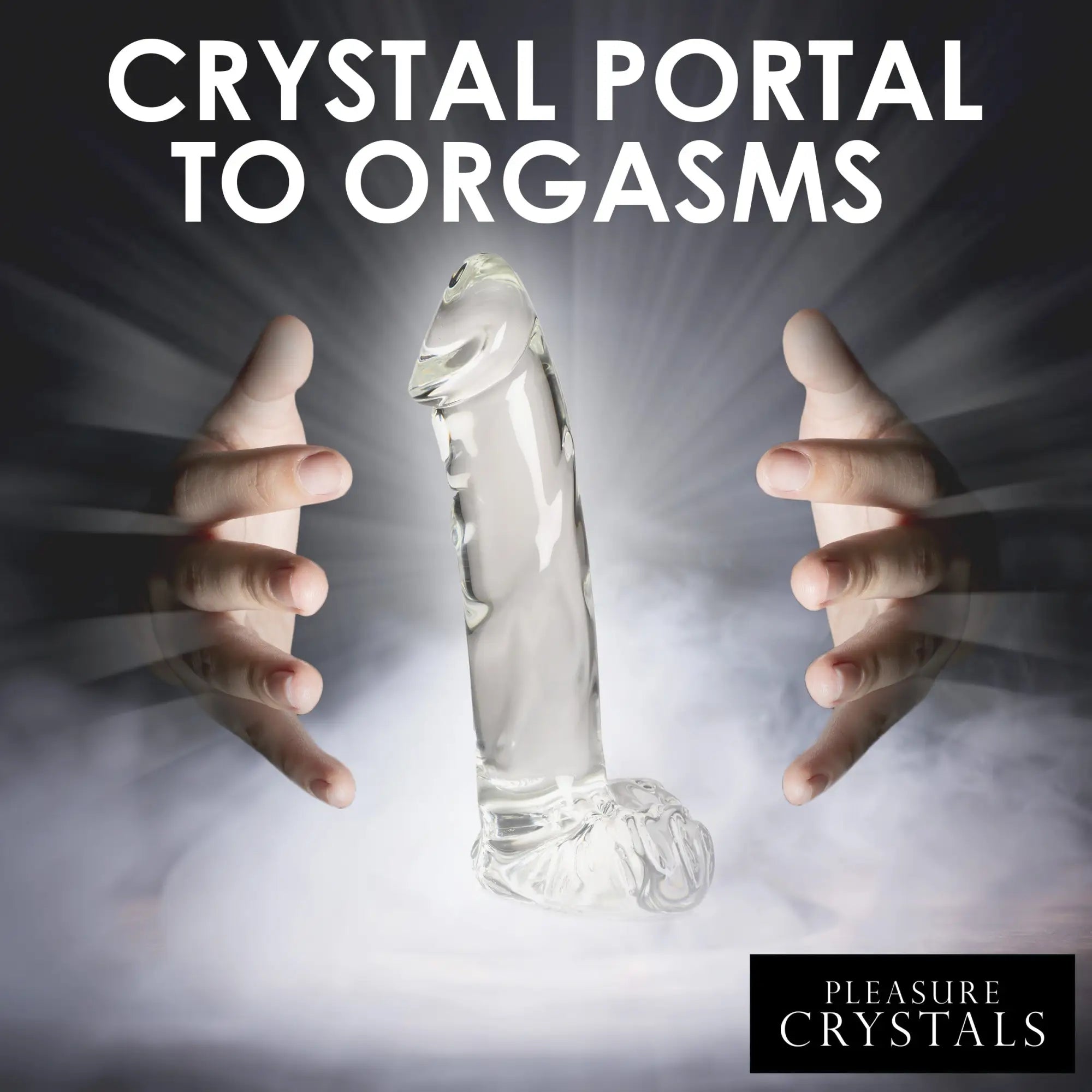 Pleasure Crystals glass dildo with balls, standing upright in mist between two cupped hands, glowing against dark background.