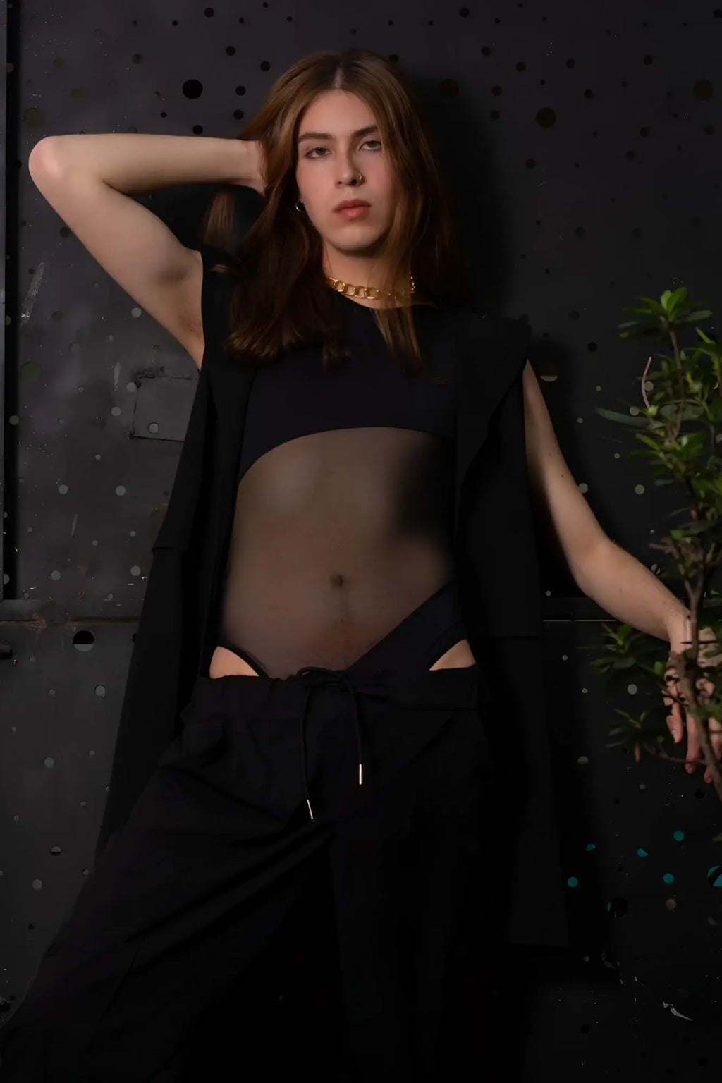 Gold chain necklace worn by a person with long brown hair paired with plural pl002 black bodysuit