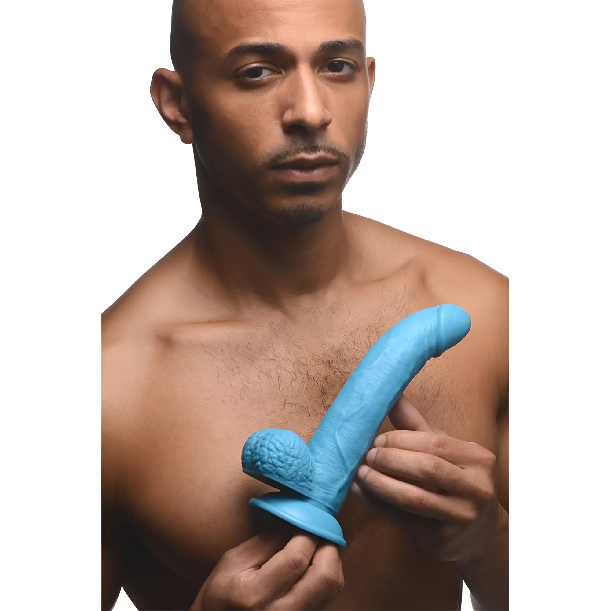 A shirtless man holds a 7.5-inch light blue, textured, curved Pop Peckers dildo featuring detailed balls and a base.