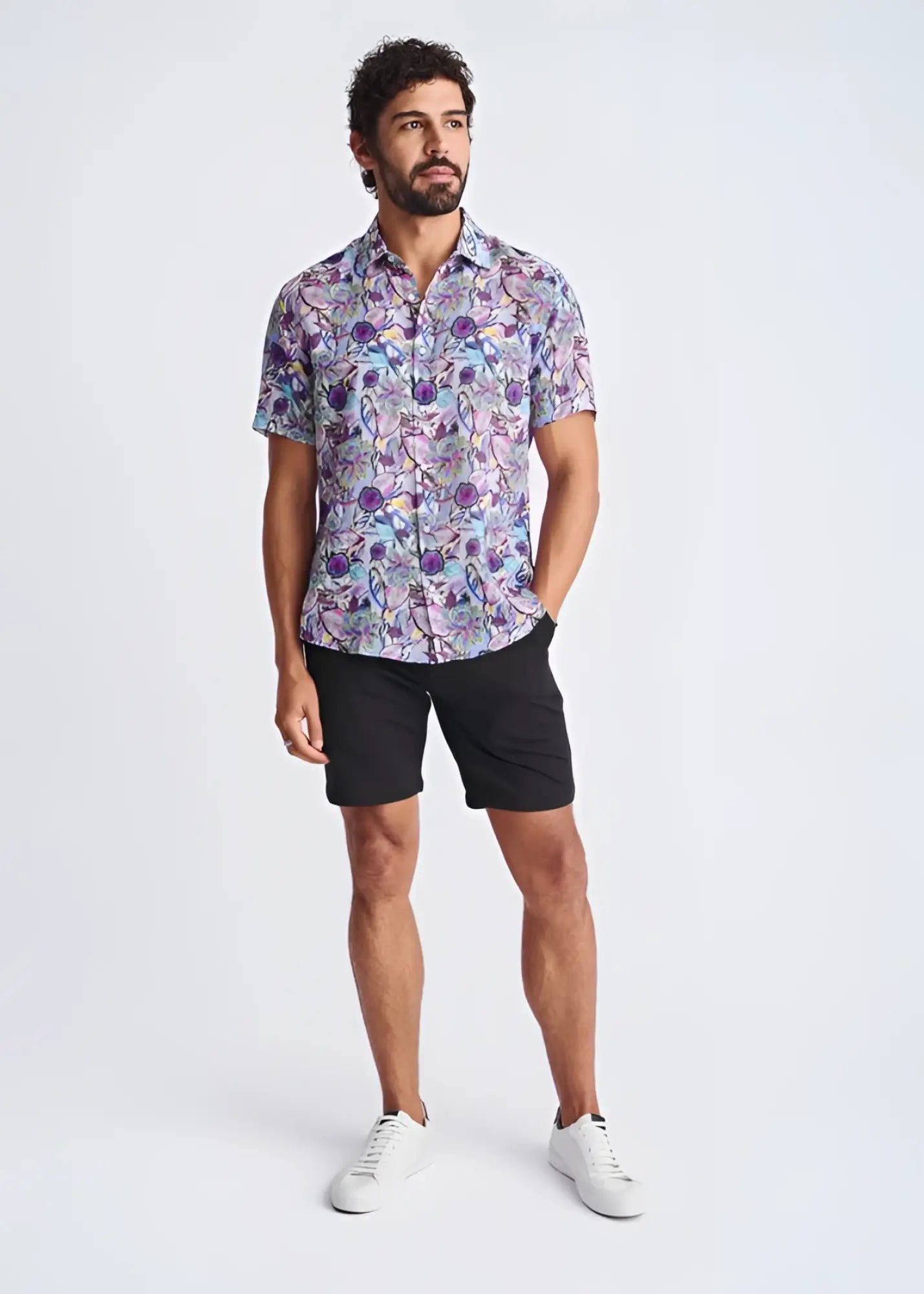 A man wearing a lightweight linen tencel short-sleeved shirt with a vibrant purple blue and pink floral pattern