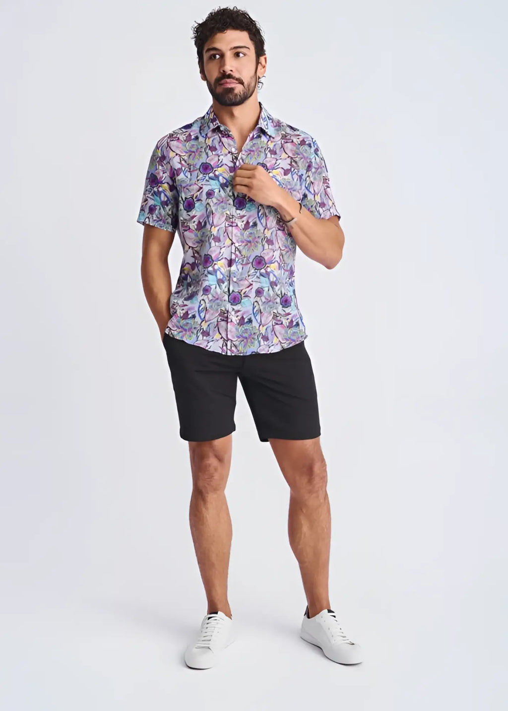 A man wearing a floral lightweight linen Tencel short-sleeved shirt in purple blue and pink tones