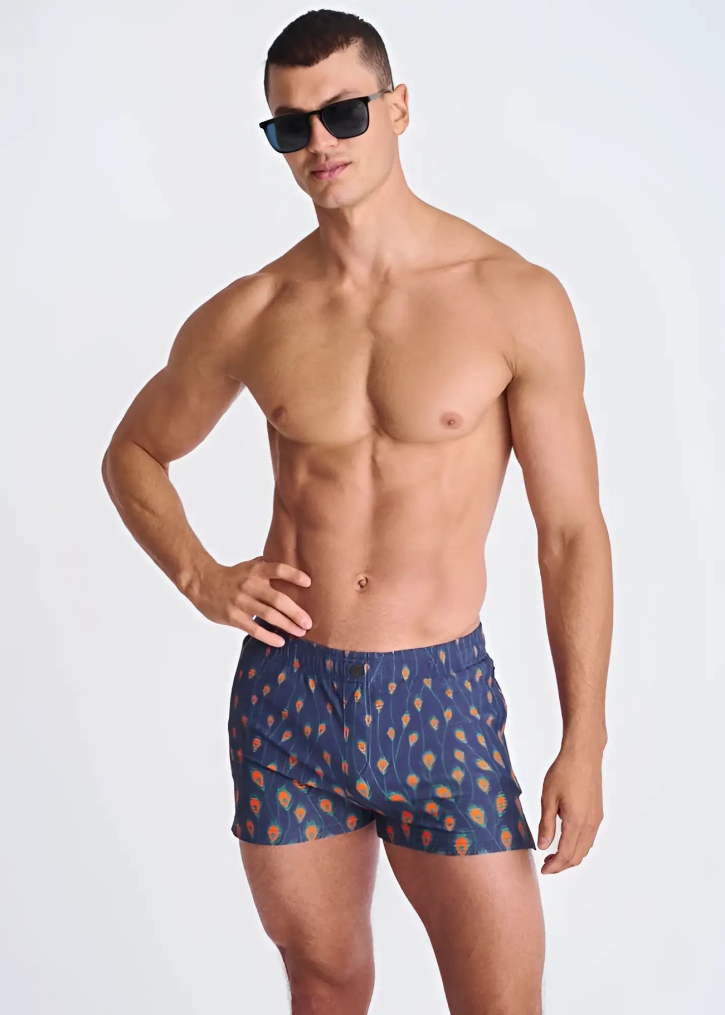 Blue swim trunks with orange and yellow feather pattern made of seersucker with mesh lining for swimming