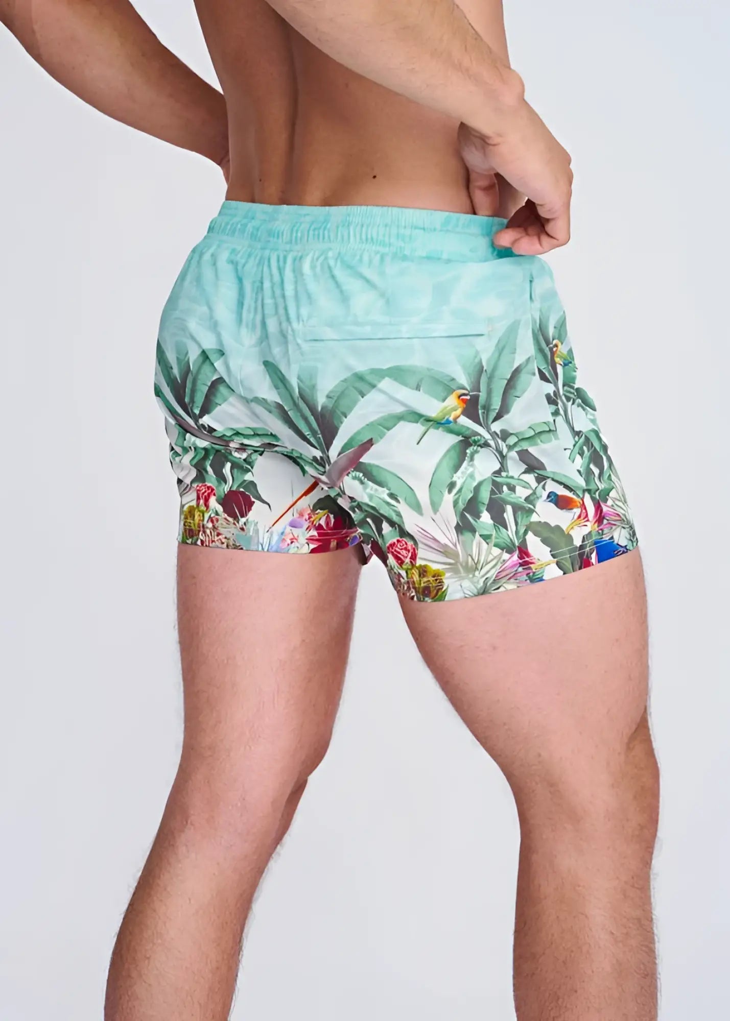 Light blue tropics print swim shorts with mesh lining featuring green leaves colorful birds and red flowers