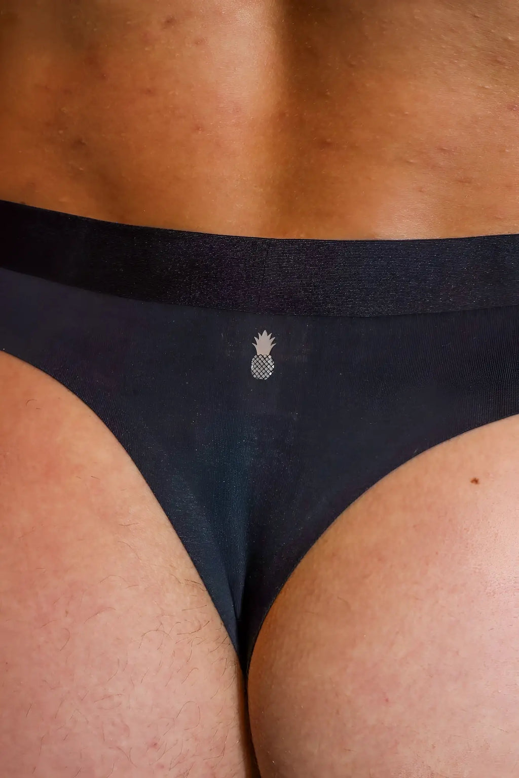 Premium modal athletic thong in noir black with a small white pineapple emblem on the front
