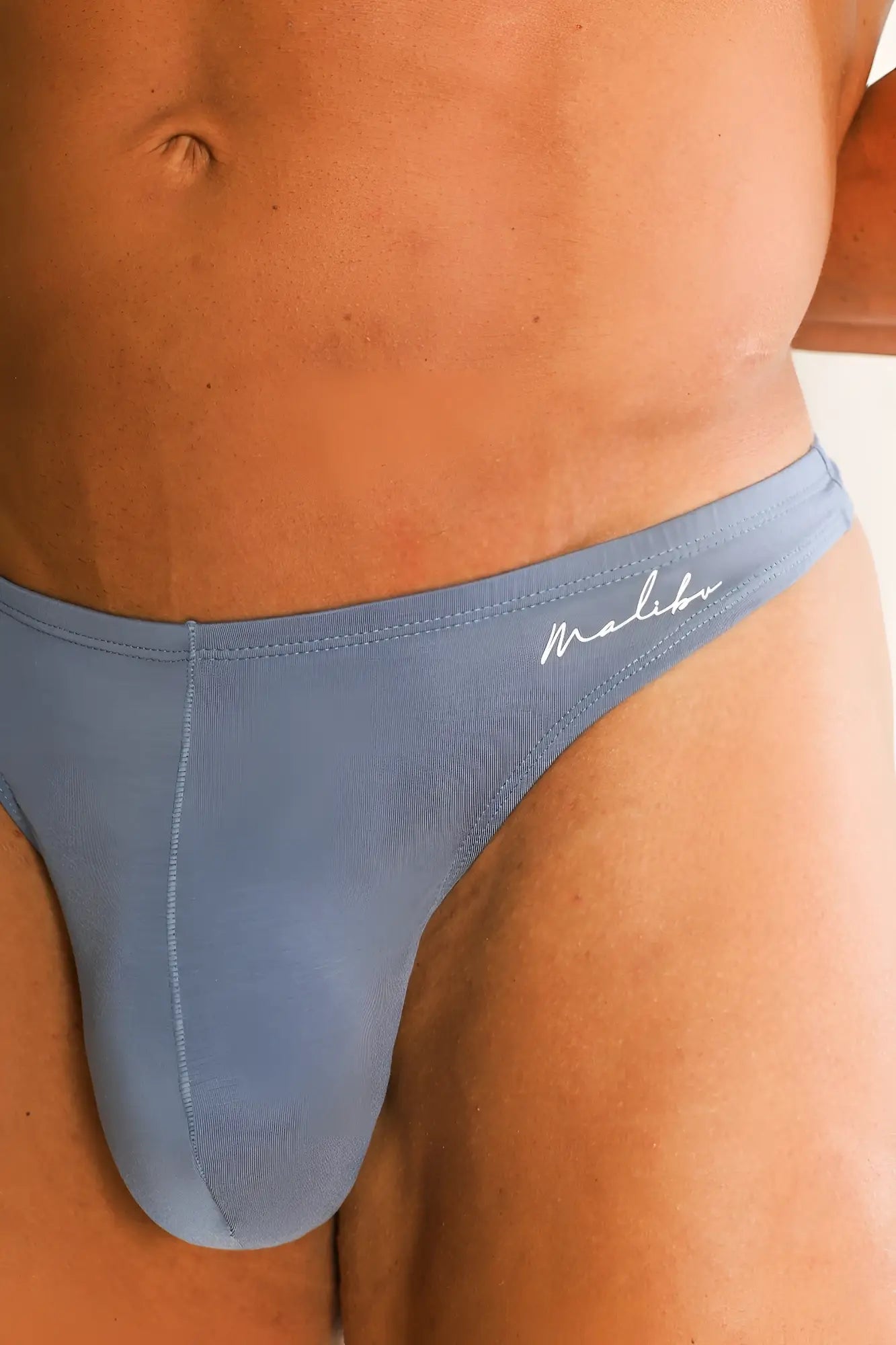 Premium modal scrunch-back thong in dusty blue with smooth form-fitting fabric and subtle stitching details back view