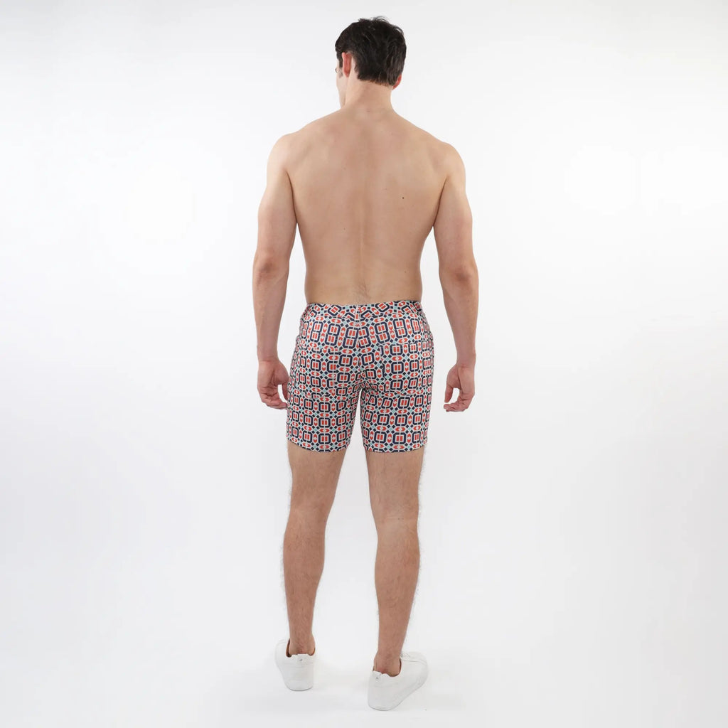 Printed stretch knit short men’s swim trunks with a vibrant red black and white geometric pattern