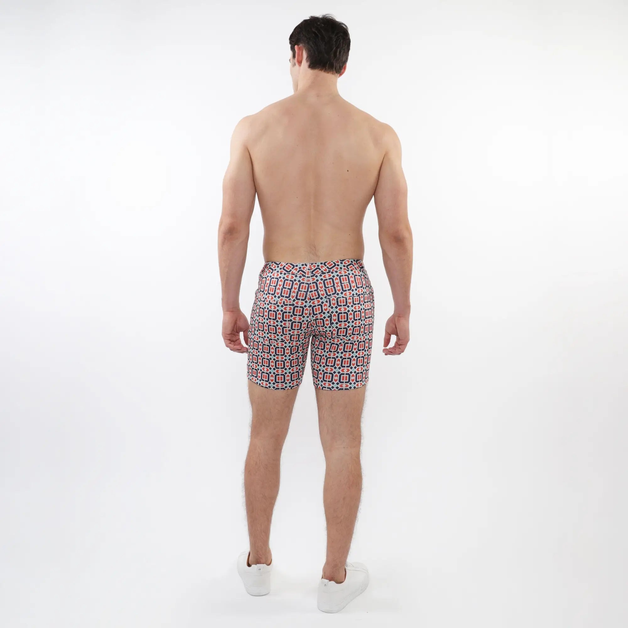 Printed stretch knit short men’s swim trunks with a vibrant red black and white geometric pattern