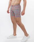 Printed stretch knit shorts with bold red navy blue and white geometric pattern on a light background