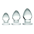 Prisms Erotic Glass 3 Piece Anal Plug Kit featuring three graduated, smooth, clear glass plugs on a white background.