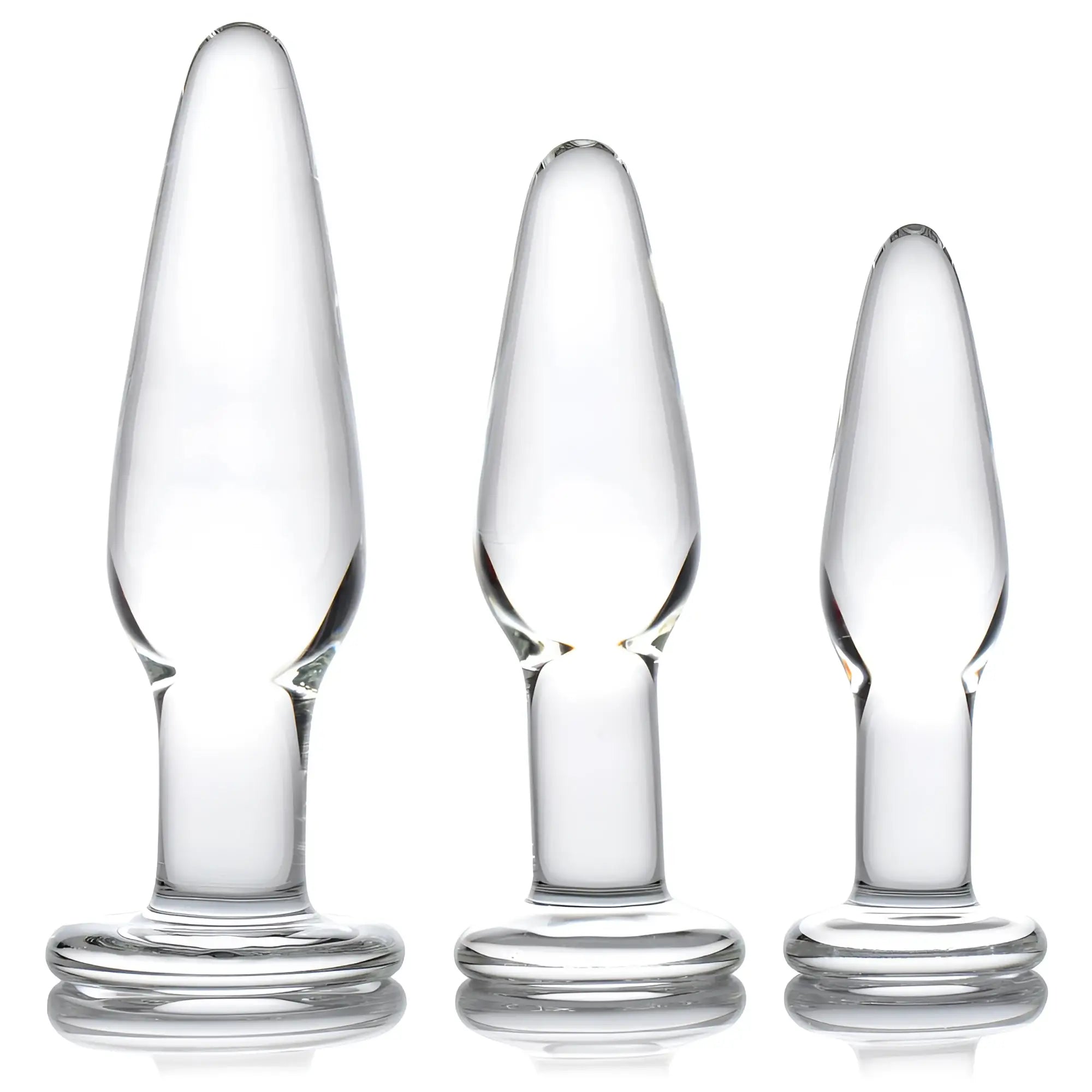 Prisms Erotic 3pc Dosha Glass Anal Plug Kit: Three clear, graduated glass plugs with flared bases on a white background.