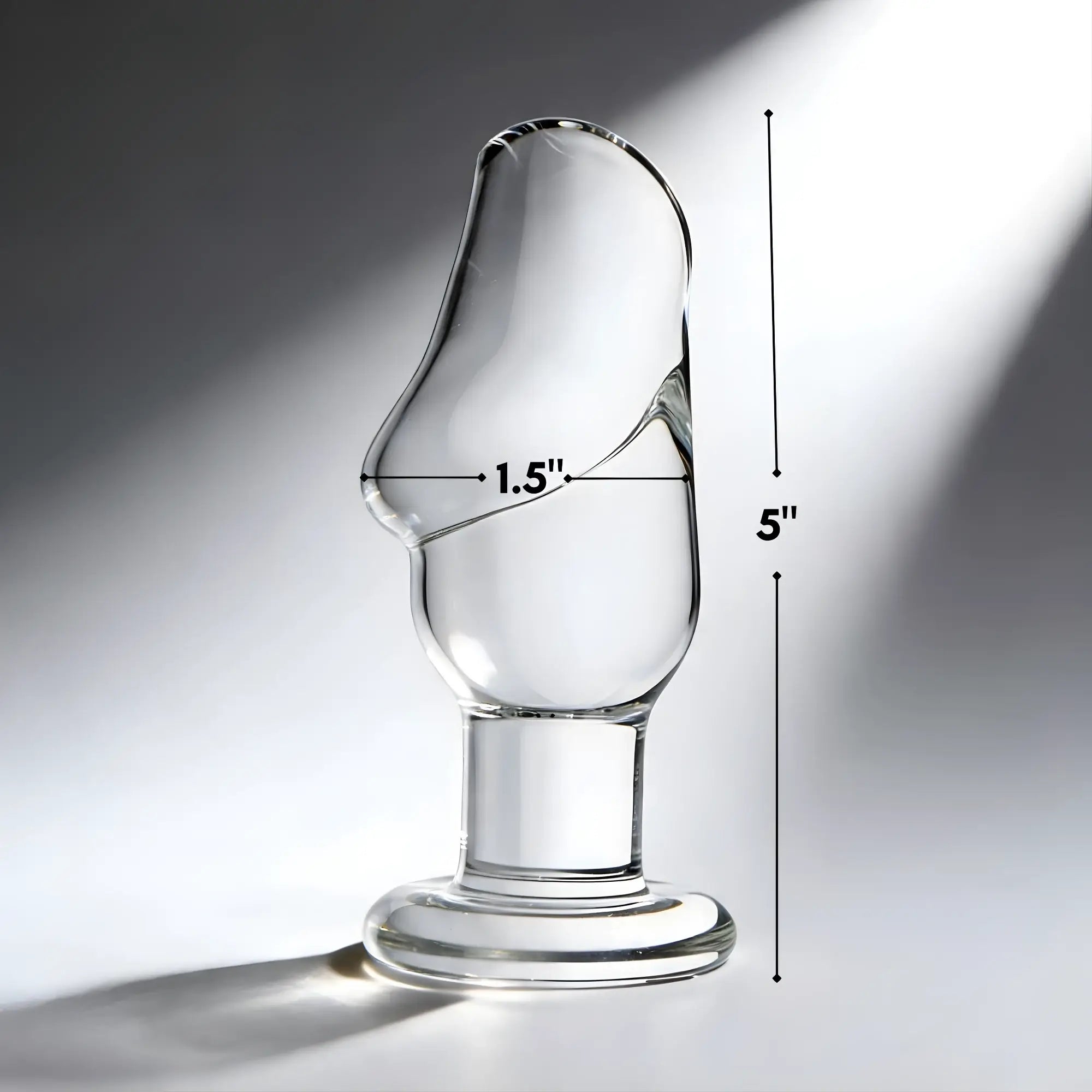 Prisms Erotic clear glass butt plug with a phallic-shaped head, measuring 5 inches tall and 1.5 inches wide.