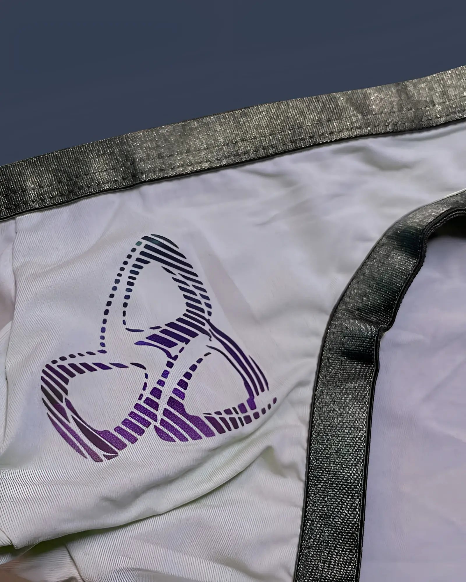 White fabric private structure brut4393 bare bikini with purple and black striped logo and shiny gray elastic waistband trim