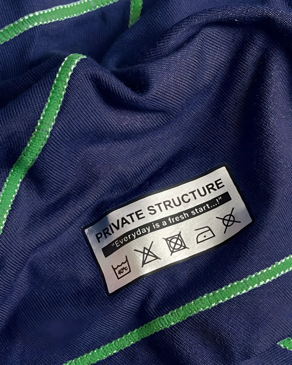 Private Structure EPUS4570 Prime Elysian hipster in navy blue ribbed knit with vibrant green stitched trim and care label visible