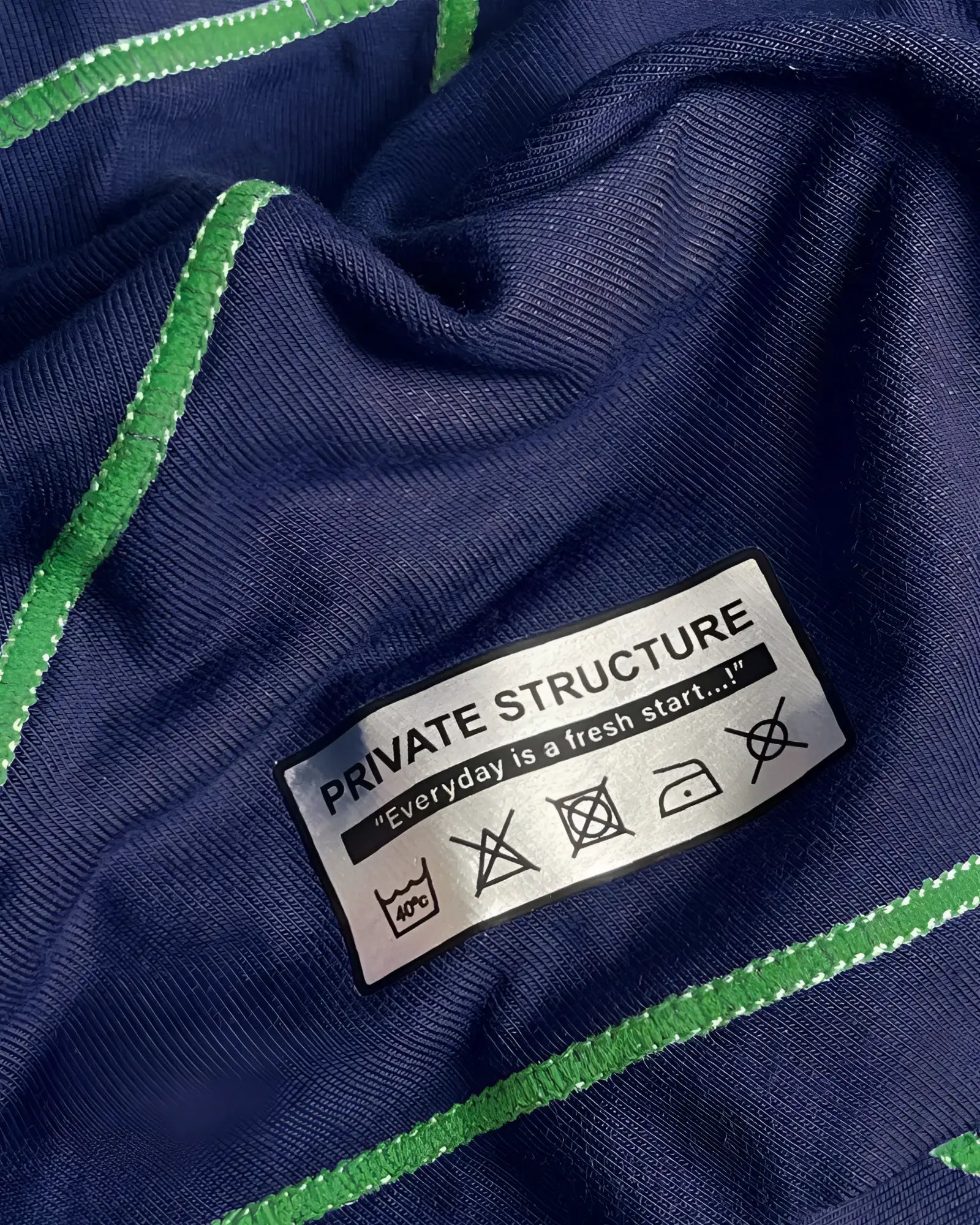 Private Structure EPUS4570 Prime Elysian hipster in navy blue ribbed knit with vibrant green stitched trim and care label visible