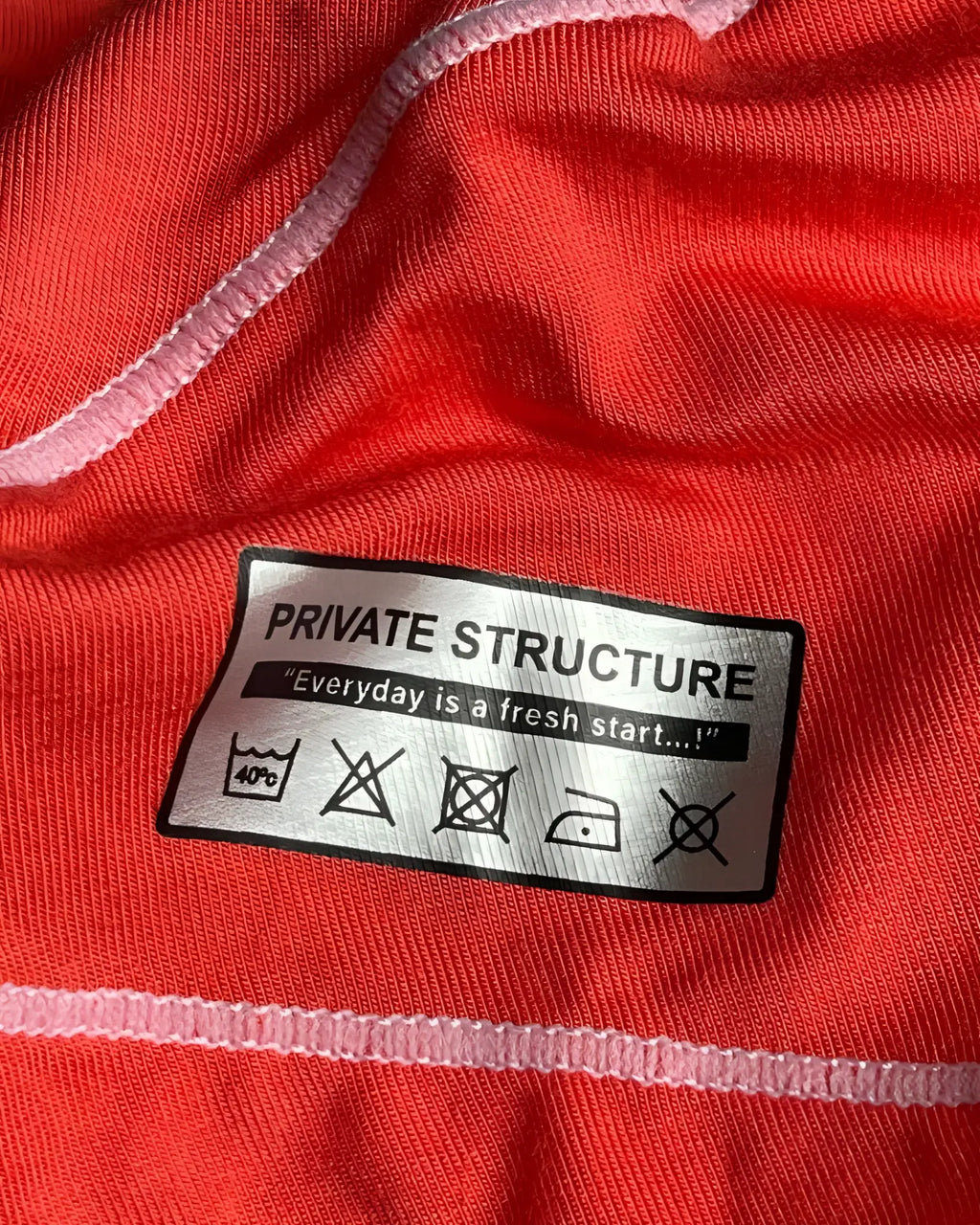 Back silver rectangular care label with black text on red private structure epus4570 prime elysian hipster underwear