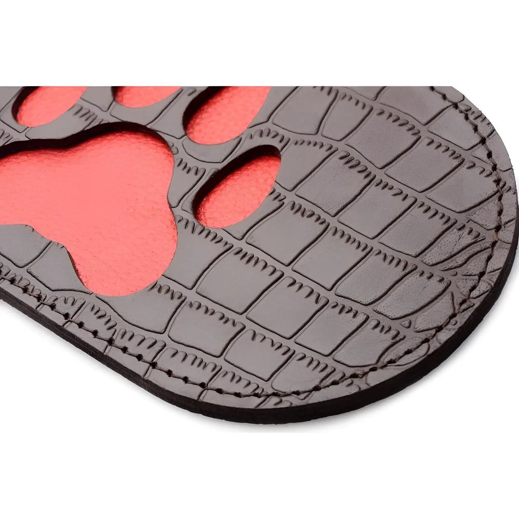 Dark gray crocodile-textured leather coaster with vibrant coral paw print cutout from puppy paw leather paddle collection