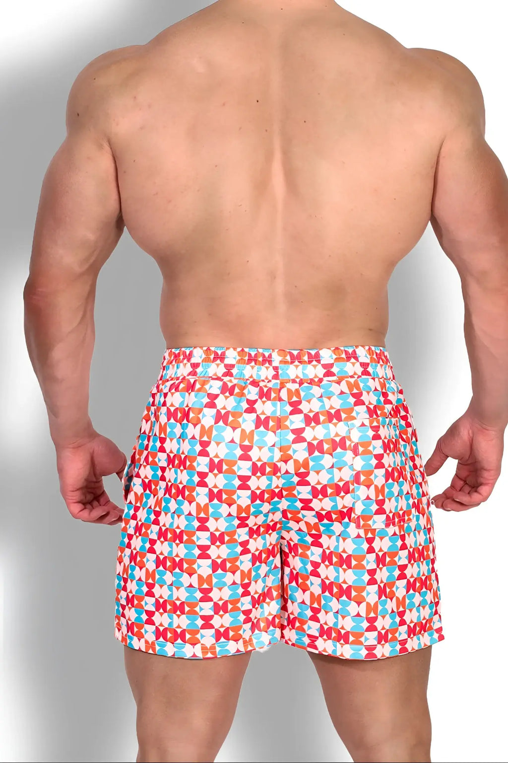 Quick-dry mesh shorts with brightly colored geometric swim trunks in red orange and light blue on white background