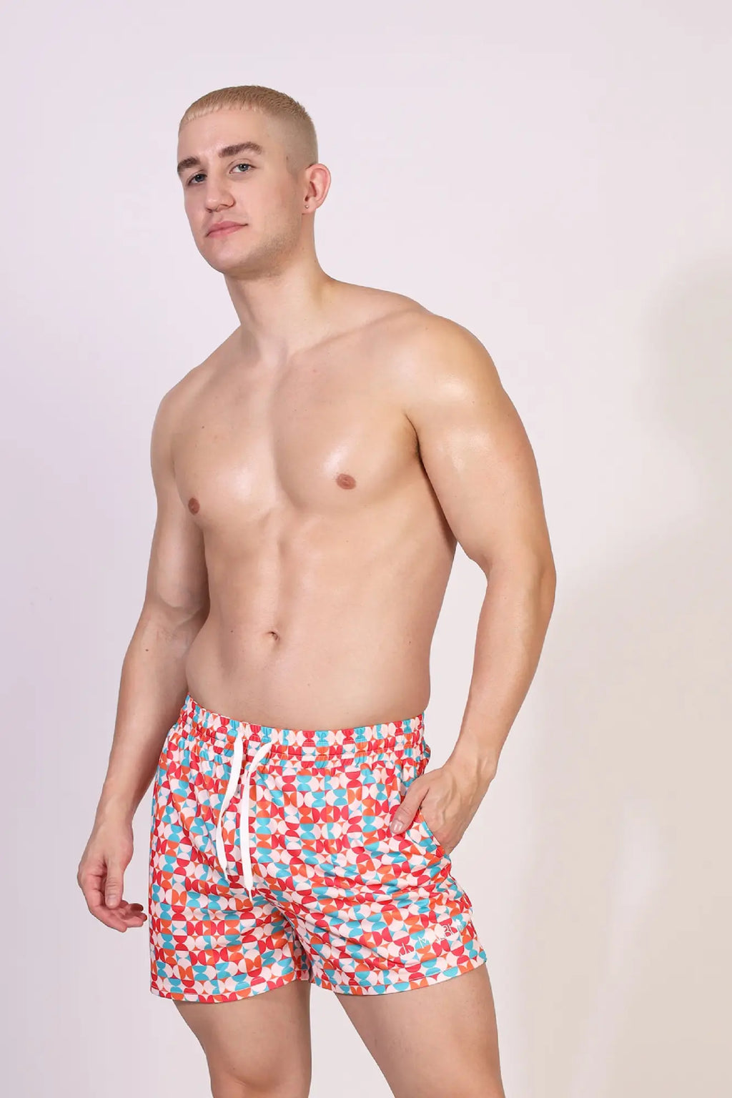 Quick-dry mesh shorts in red blue and white geometric pattern with drawstring waistband for swim and casual wear