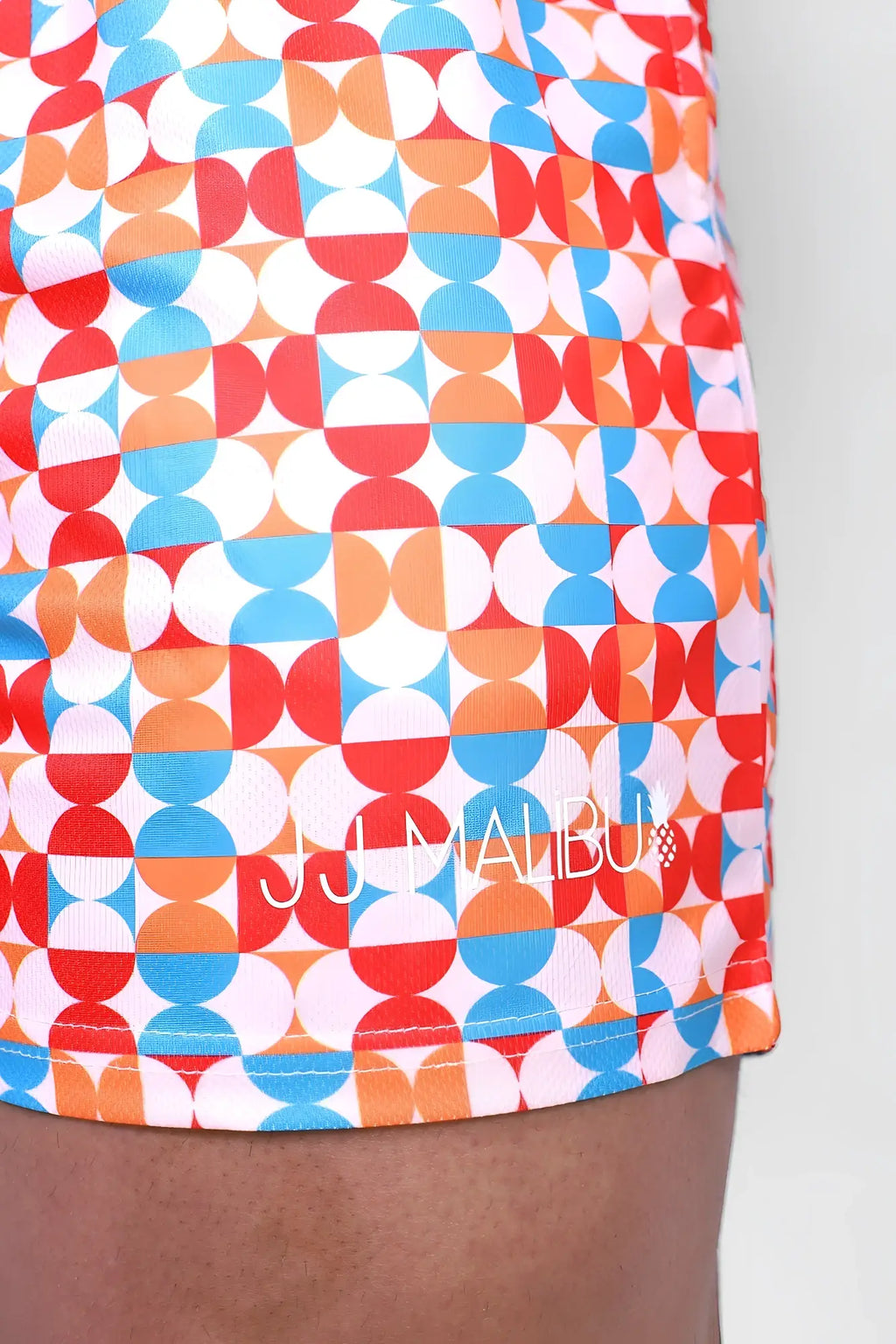 Quick-dry mesh shorts with vibrant red blue and orange geometric pattern and white jj malibu logo front side visible