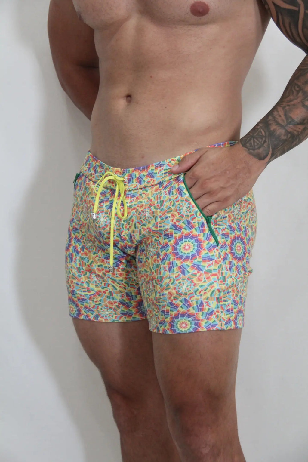 Rainbow kaleidoscope linen texture shorts with vibrant multicolored geometric pattern neon yellow drawstring and green zipper accents