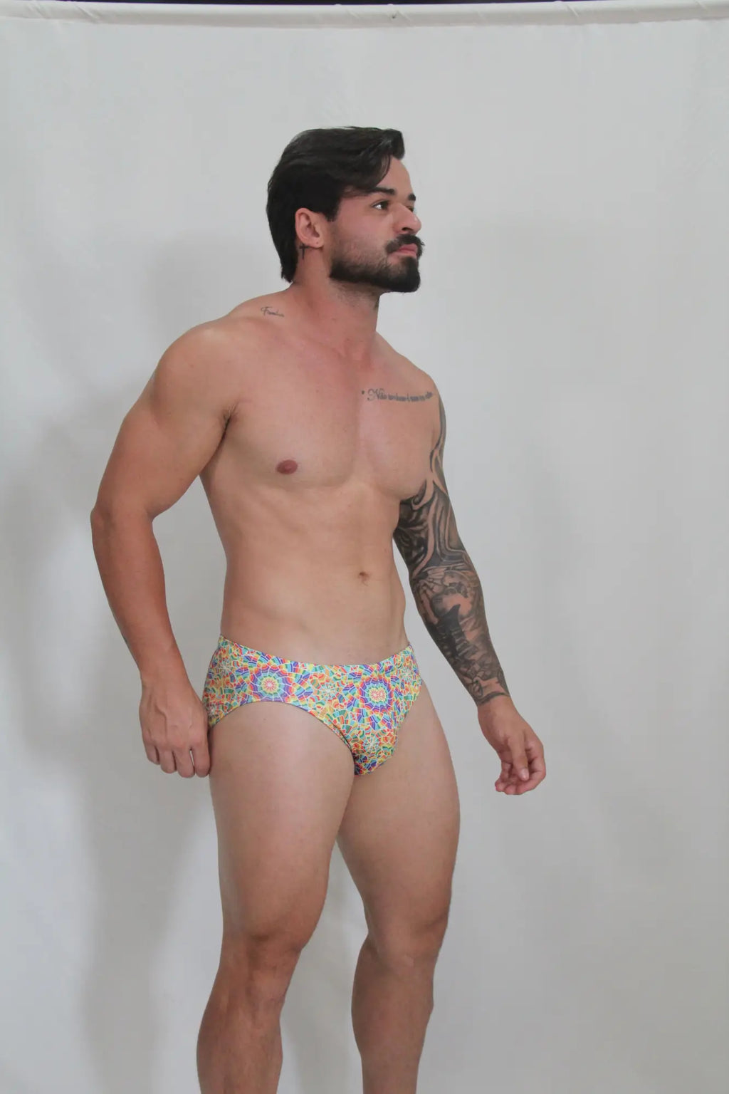 Vibrant rainbow kaleidoscope swim brief with colorful blue yellow and red geometric pattern perfect for swimming