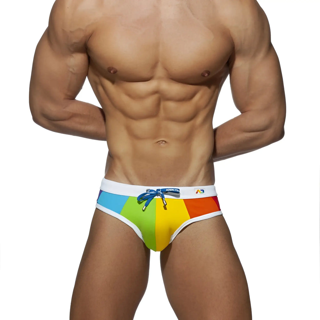 Rainbow swim brief with rainbow-striped fabric, white waistband, and blue drawstring perfect for swimming and beachwear