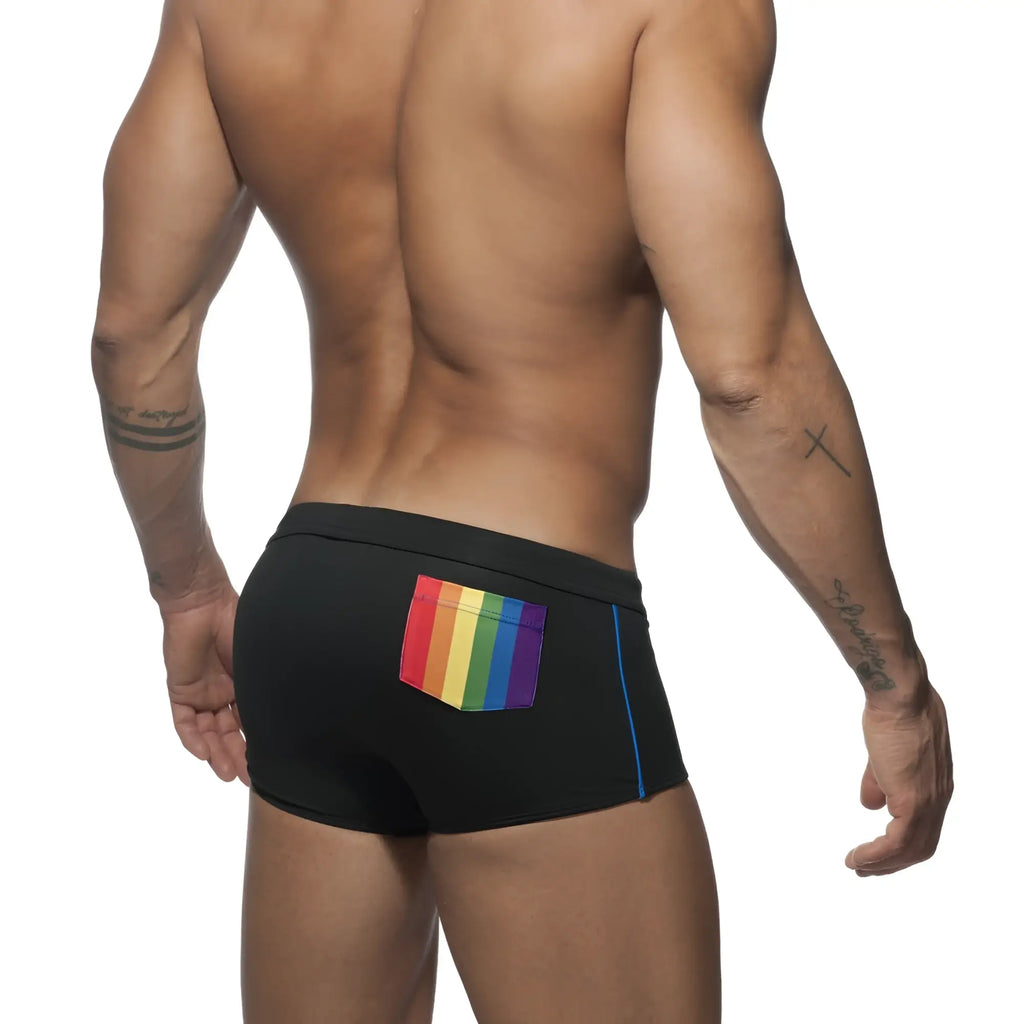 Black swim trunks with a vibrant rainbow-colored pocket and blue side trim designed for swimming and beachwear