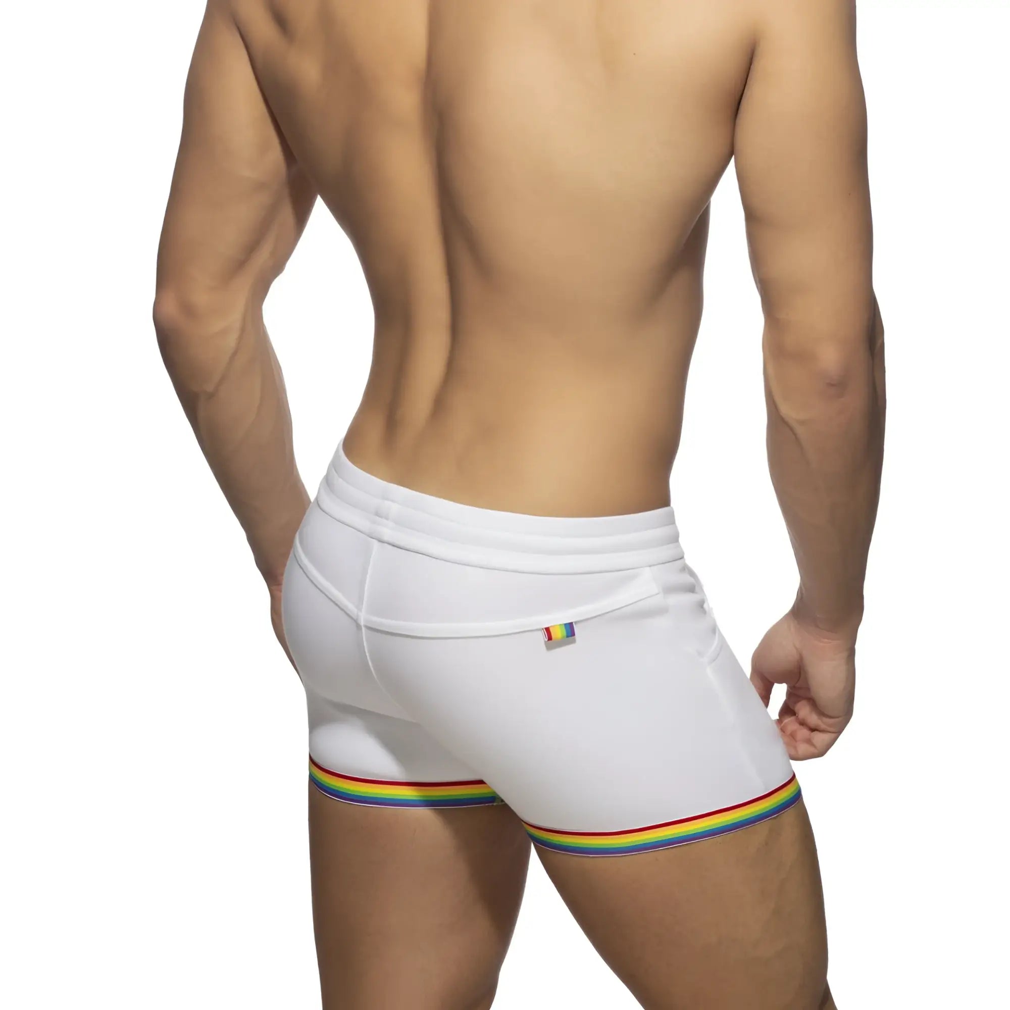 White cotton athletic shorts with rainbow stripe hem and small rainbow flag logo on back waistband shown from behind
