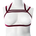 A shimmering burgundy velvet gender fluid harness top with strappy crisscross design in raspberry glitter finish
