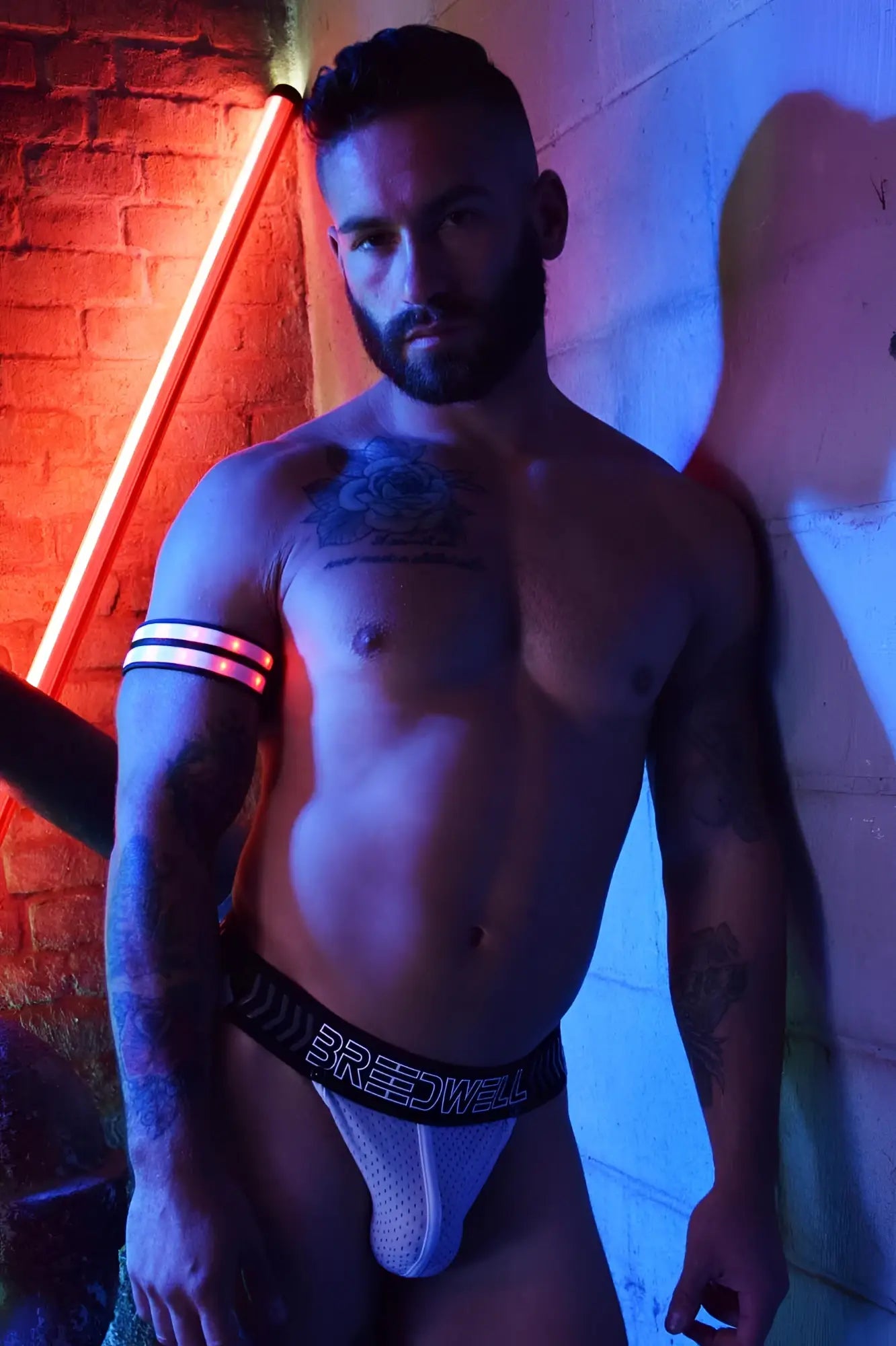 White mesh briefs with black elastic waistband featuring breedwell branding for rave armband use
